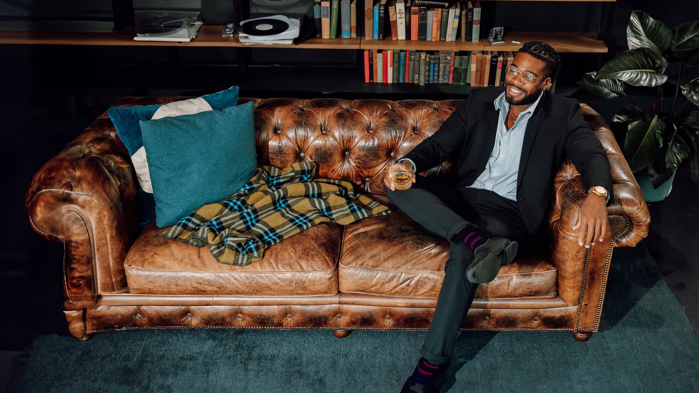Man sitting on couch with glass of whiskey